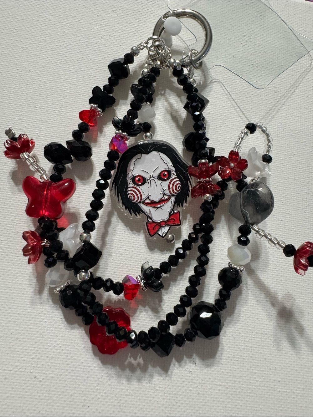 Handmade Black & Red Horror Puppet Charm Beaded Phone Charm. From the movie Saw.